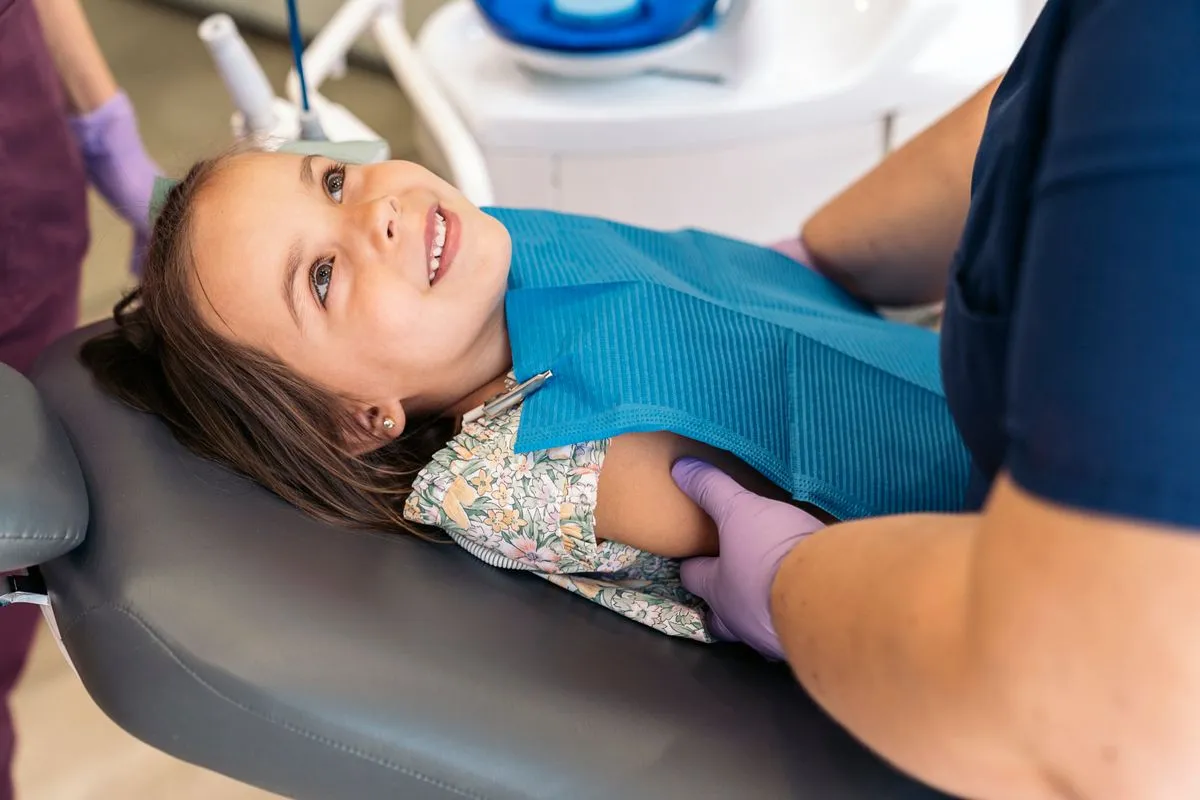 Dentist applying protective dental sealant to a patient's tooth surface